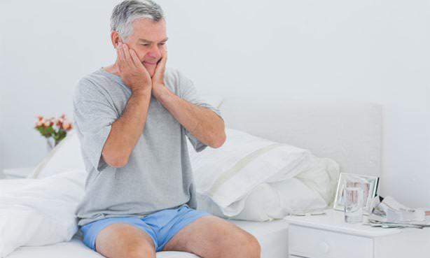 Мужчина пытается встать с кровати