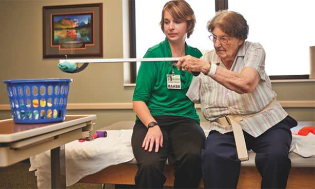 Реабилитолог работает с парализованной рукой