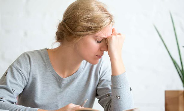 Головная боль у женщины в районе лба и висков
